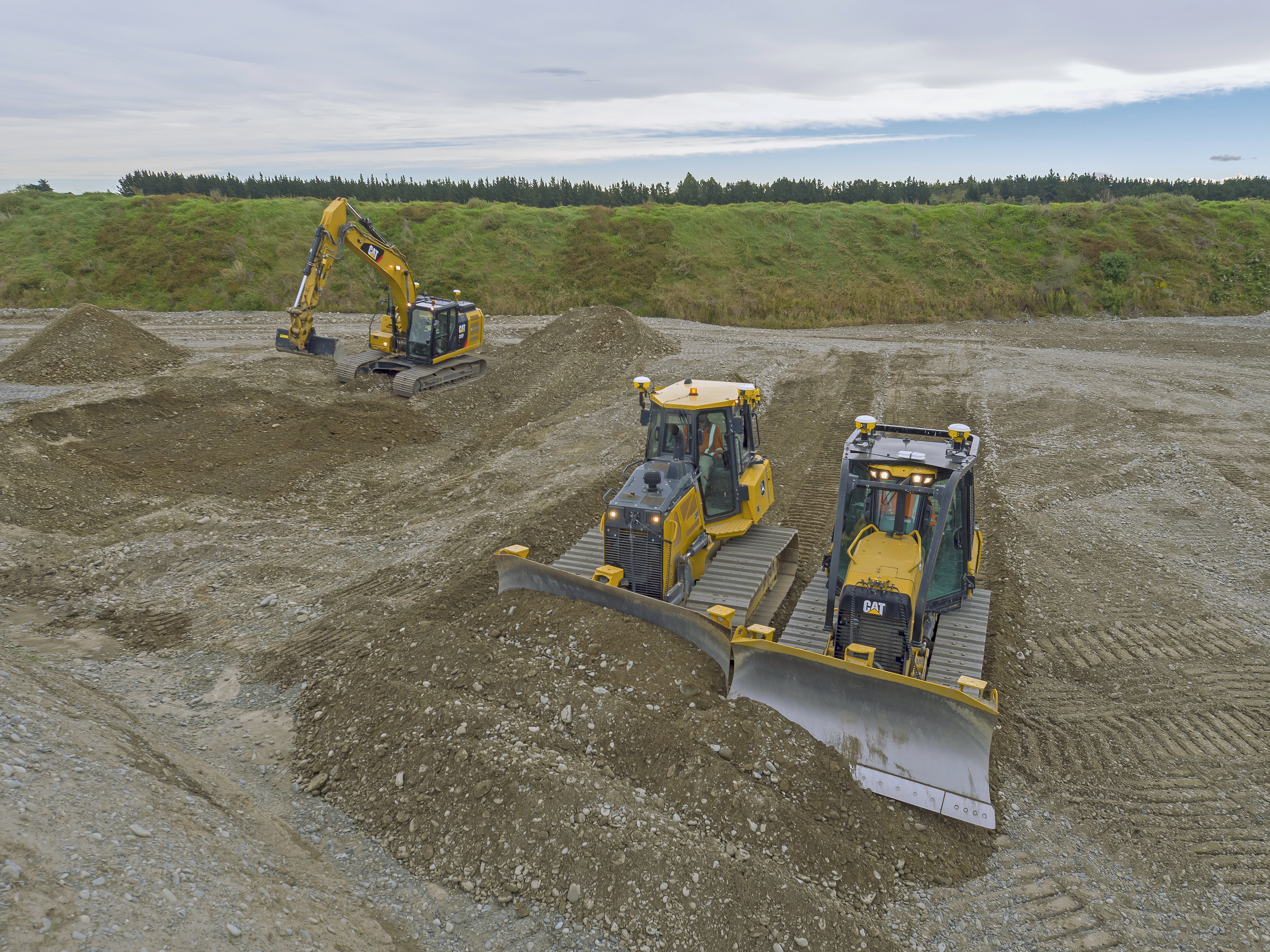 Máquinas pesadas com SITECH a realizar trabalhos de terraplanagem num grande estaleiro. Escavadora Caterpillar e bulldozers a trabalhar eficazmente em projetos de construção e desenvolvimento. 