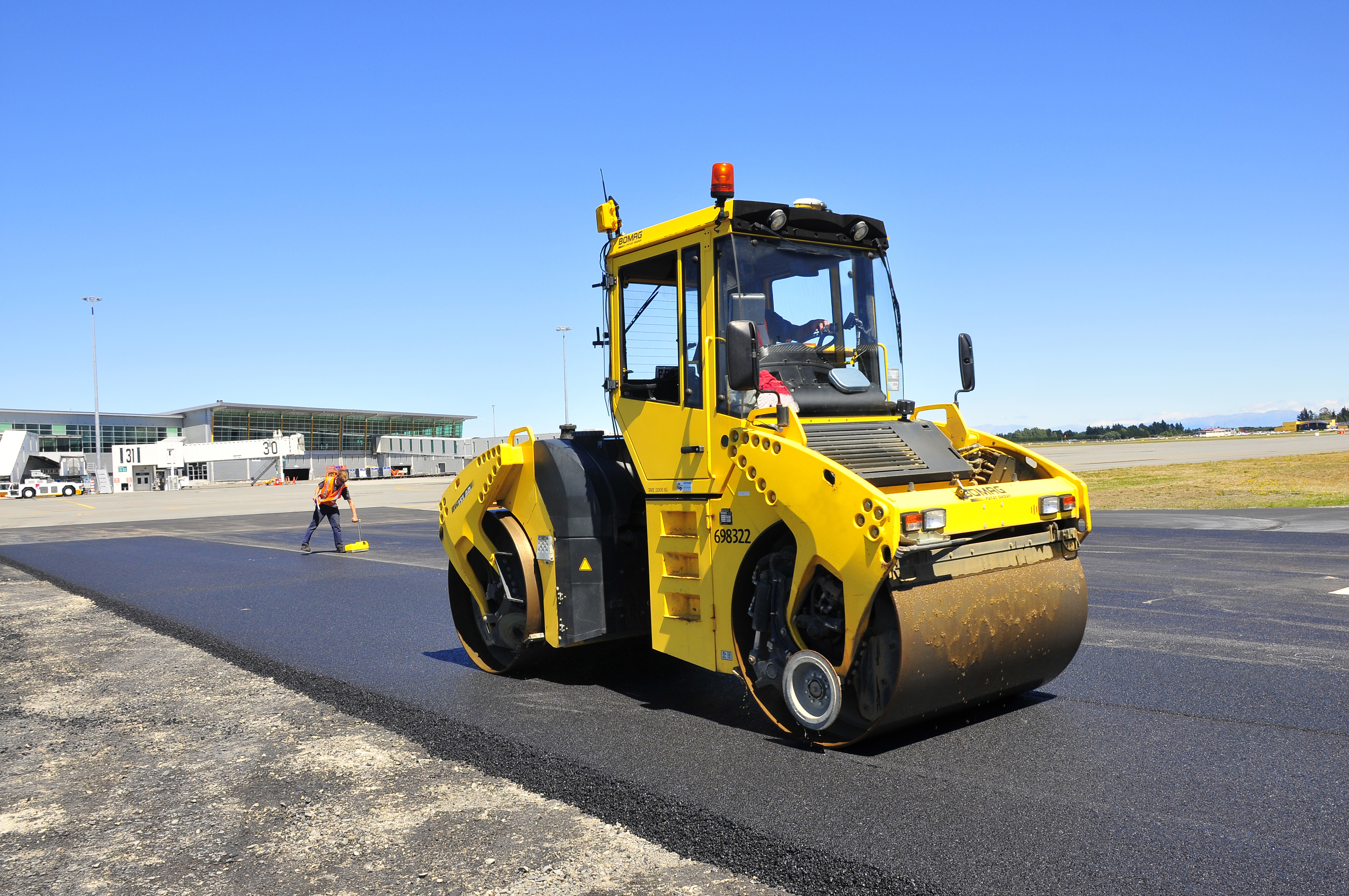 Compactador amarelo bomag em ação sobre asfalto, com tecnologia de sistema 3D para uma compactação precisa e eficiente