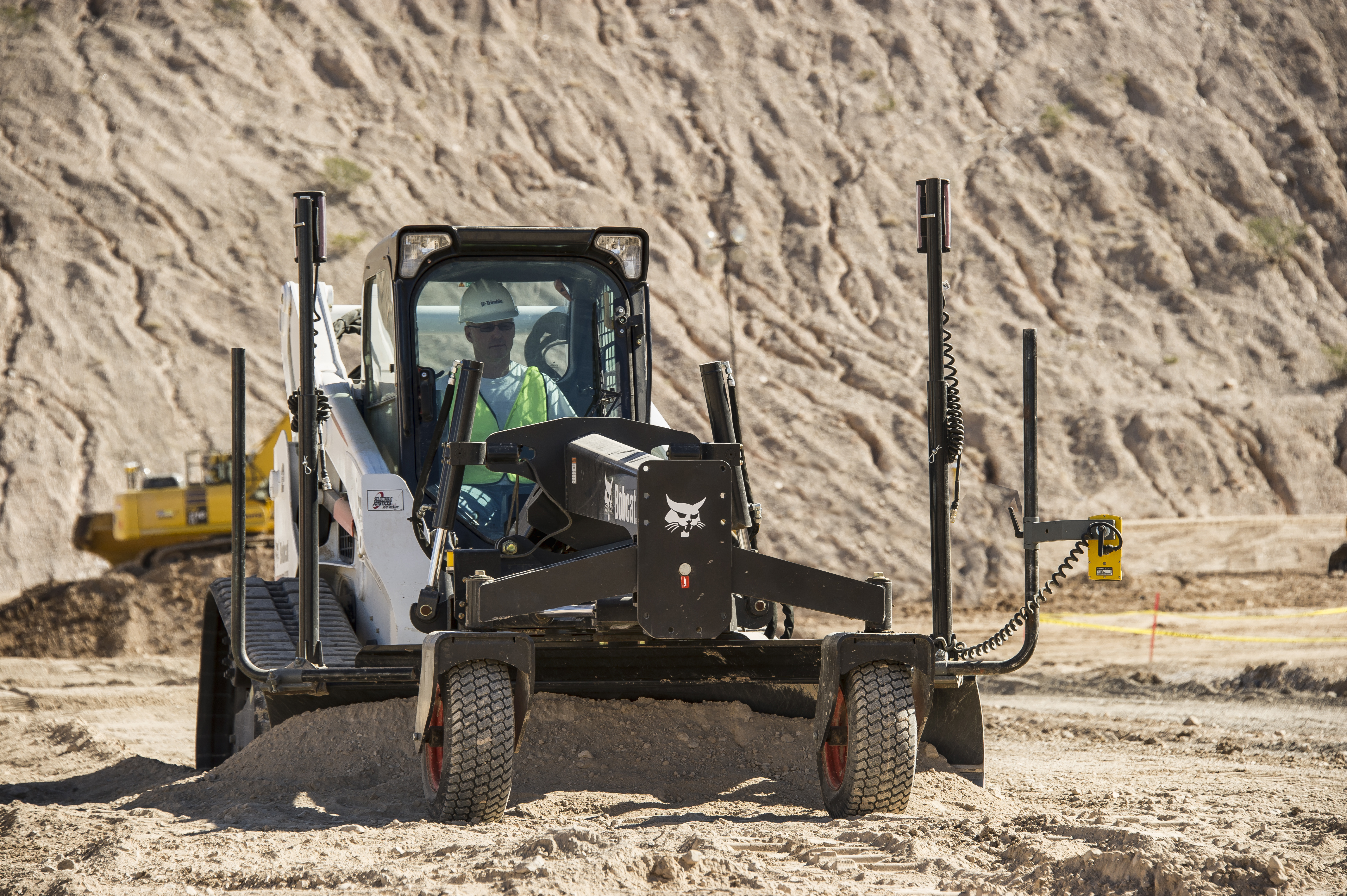 Minicargadora en operación en un sitio de construcción y equipada con sensores y controles del Sistema 2D Trimble Earthworks