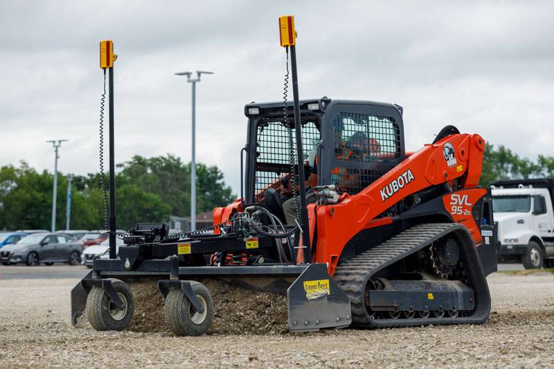 Carregadora compacta Kubota equipada com o sistema de controlo de nivelamento Trimble Earthworks GO! num sítio de obras de cascalho, demonstrando tecnologia de construção avançada para precisão e eficiência