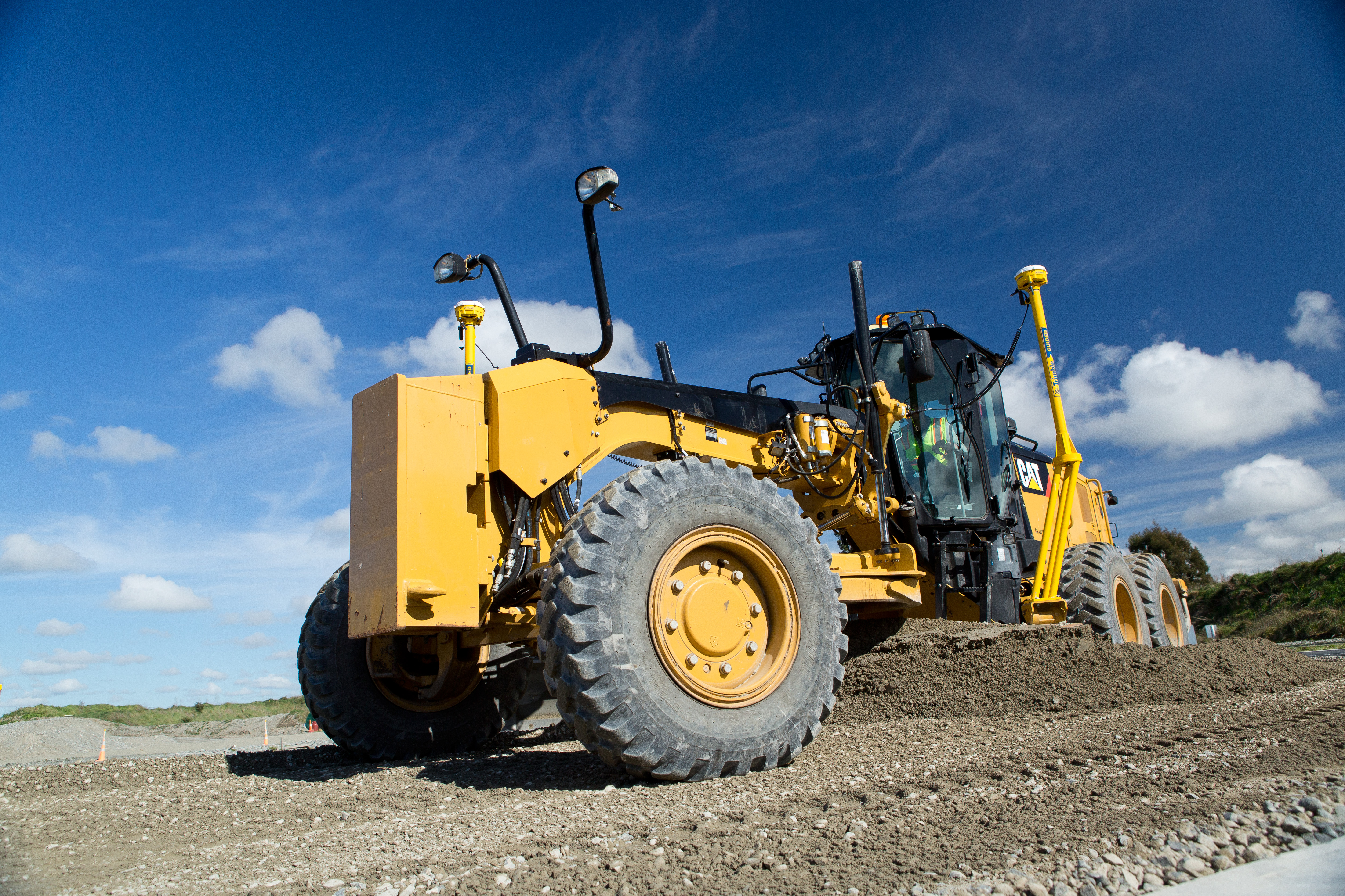 Motoniveladora amarela com o Trimble Earthworks 3D a operar num terreno de construção baixo, destacando a tecnologia avançada para nivelação precisa em projetos de engenharia civil